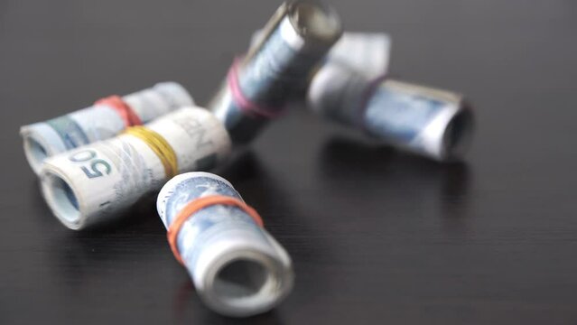 He throws money bound with a rubber band on the table. A roll of banknotes.