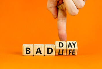 Bad day or life symbol. Businessman turns wooden cubes and changes concept words Bad life to Bad day. Beautiful orange table orange background. Business and bad day or life concept. Copy space. - obrazy, fototapety, plakaty
