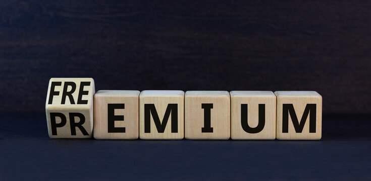 Premium or freemium symbol. Turned wooden cubes and changed the concept word Premium to Freemium. Beautiful black table black background. Business premium or freemium concept. Copy space.