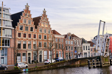 Fototapeta na wymiar Haarlem, The Netherlands - April 11, 2022: Gravestenen drawbridge raised over Spaarne river with gable canal houses.