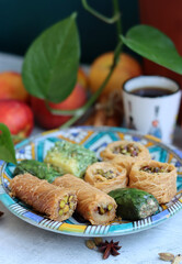 Top view photo of Israeli pastries on a plate. Traditional dessert made of phyllo dough stuffed with ground pistachios. 