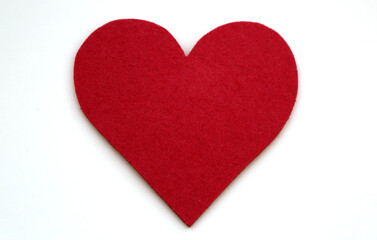 Red colored heart shape made of felt shot on white.