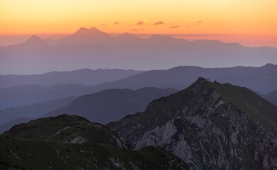 Sunrise mountains silhouette in the Julian Alps. Beautiful morning at the summit of the hills. 