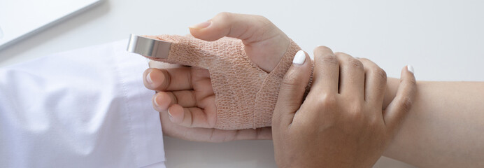 Doctor is looking at the patient's finger splint, finger straight with orthopedic device, Treatment...