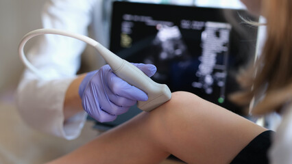 Doctor conducting ultrasound examination of knee joint in child closeup - Powered by Adobe