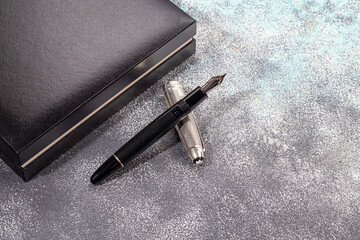 Fountain pen on a marble and gray background. Selective focus.