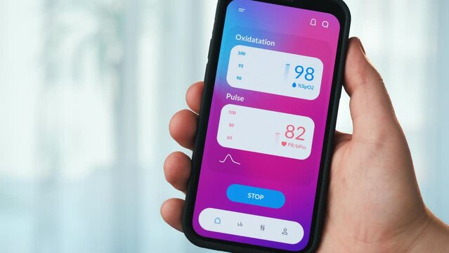 Man checks oxygen saturation on his smartphone. Pulse oximeter app for mobile phone.
