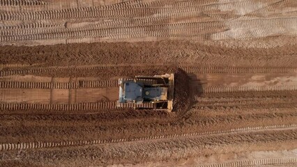 Dozer has been recovering the landscape around the open pit. Process of restoring land. Bulldozer at mine reclamation once mining sand is completed. Clearing land. 