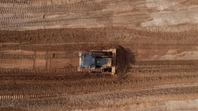 Dozer has been recovering the landscape around the open pit. Process of restoring land. Bulldozer at mine reclamation once mining sand is completed. Clearing land. 