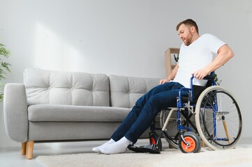 Disabled young black guy trying sit down.