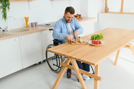 man in a wheelchair cuts vegetables in the kitchen