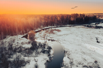 Winter landscape with trees and river from above at sunset time