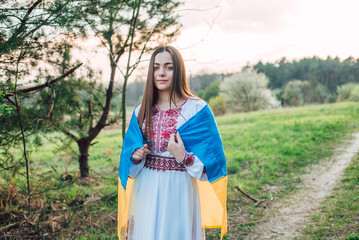 portrait of young beautiful Ukrainian woman in vyshyvanka  - ukrainian national clothes. Woman in countryside.  Stand with Ukraine  
