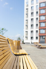 Several new wooden benches stand in the courtyard of the building. Calm and relaxing outside on a sunny day.