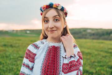 portrait of young beautiful Ukrainian woman in vyshyvanka  - ukrainian national clothes outdoors in countryside during sunset. Stand with Ukraine  
