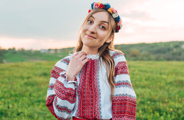 portrait of young beautiful Ukrainian woman in vyshyvanka  - ukrainian national clothes outdoors in countryside during sunset. Stand with Ukraine  