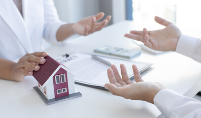 Real estate broker agents advise clients to make a decision to buy a house with insurance. Negotiating purchase-sale and investment planning concept.