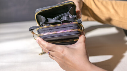 Close up woman hand holding a woman's wallet on abstract white background
