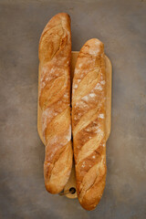 Fresh baguette with crispy crust on a concrete table