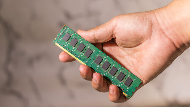 Close up male hand holding a ddr3 computer ram on abstack white background