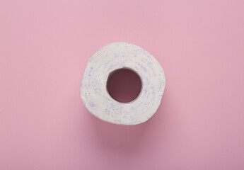 Roll of toilet paper on a pink background. top view