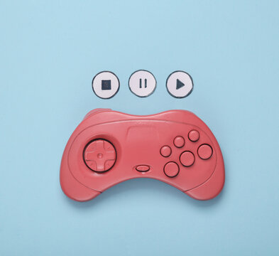 Pink Gamepad and icons start, stop, pause on bkue background. Video game competition. Top view
