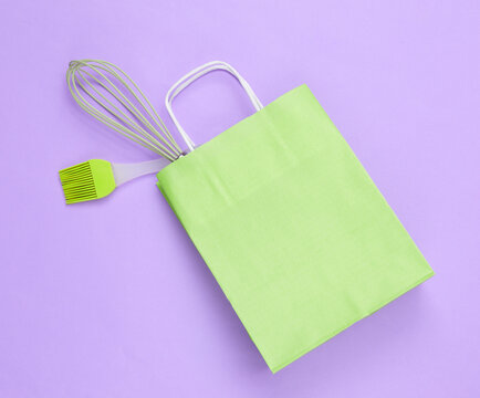 Paper shopping bags and Kitchen tools on purple background.