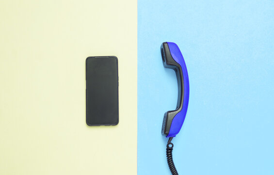 Retro cable phone tube and modern smartphone on yellow blue background