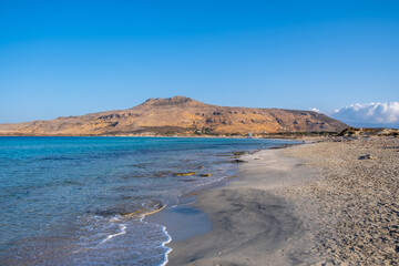 Fototapeta na wymiar Empty sandy rocky beach, Greece. Elafonisos, island. Sea water turquoise color, sunny summer day