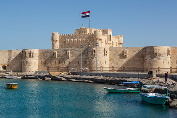 Alexandria, Egypt - January 2022: Citadel of Qaitbay fortress and a small lake with boats in front 