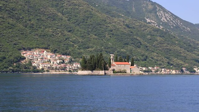Island of St. George near town Perast in Bay Kotor, Montenegro. Picturesque high mountains near sea, covered with forest in Montenegro. Place for sea tourism, sports, recreation, hiking