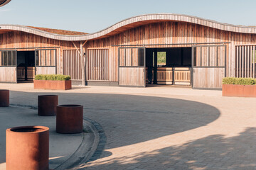design stables in a horse education center - modern horse farm with wooden and steel structures - daylight - obrazy, fototapety, plakaty