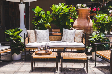 Home decor interior design with an outdoor room in the backyard with comfortable seating couches, plants and tables