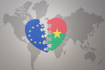 puzzle heart with the national flag of european union and burkina faso on a world map background. Concept.