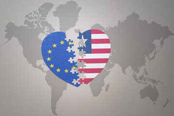 puzzle heart with the national flag of european union and liberia on a world map background. Concept.