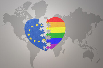 puzzle heart with the national flag of european union and rainbow gay flag on a world map background. Concept.