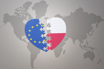 puzzle heart with the national flag of european union and poland on a world map background. Concept.