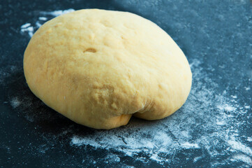 Fototapeta na wymiar loaf with dough on a board with flour. round bread on a dark texture. bread baking concept.