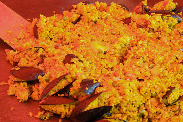 pan with paella with rice seafood and mussels under the infrared lamp to keep the heat of the dish