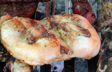 big open chicken breast cooked on the coals over the grill in the restaurant