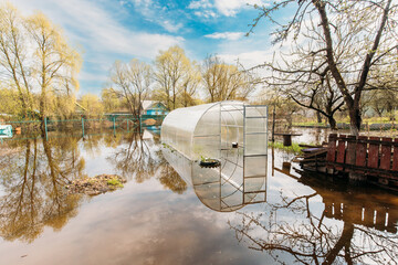 Vegetable Garden Beds In Water During Spring Flood floodwaters during natural disaster. Greenhouse...
