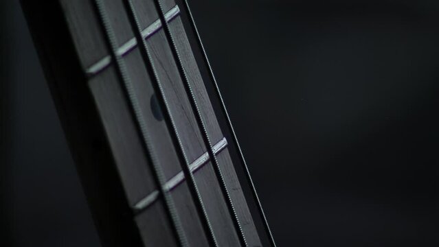 Detail of Fretboard on a Bass Guitar with Its Strings Vibrating. Close Up.