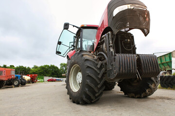 Agricultural machinery repair, open tractor hood, modern engine, tractor maintenance.