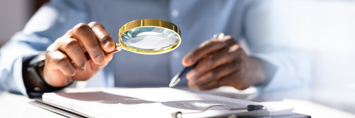 Human Hand Holding Magnifying Glass Over Invoice