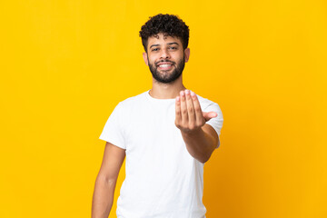 Young Moroccan man isolated on yellow background inviting to come with hand. Happy that you came - obrazy, fototapety, plakaty
