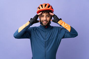 Young Moroccan cyclist man isolated on purple background with surprise expression - obrazy, fototapety, plakaty