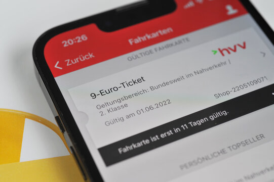Hamburg, Germany - May 21, 2022: Germany's 9-Euro-ticket blurred on a smartphone  - the ticket is part of a package of measures designed to cushion consumers from the rising price of energy