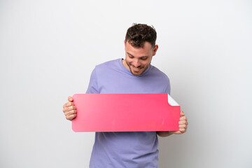 Young Brazilian man isolated on white background holding an empty placard