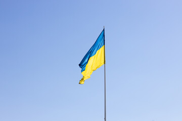 The state flag of Ukraine on a background of blue sky