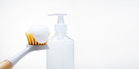 dishwashing brush with foam on light background. banner with copy space.